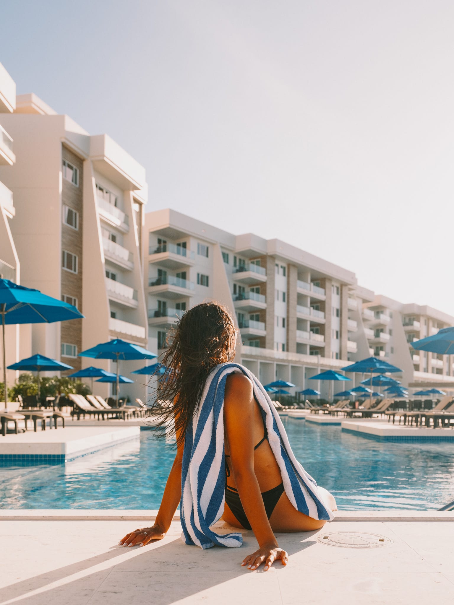 Guest walking beside a waterfront resort pool in Belize