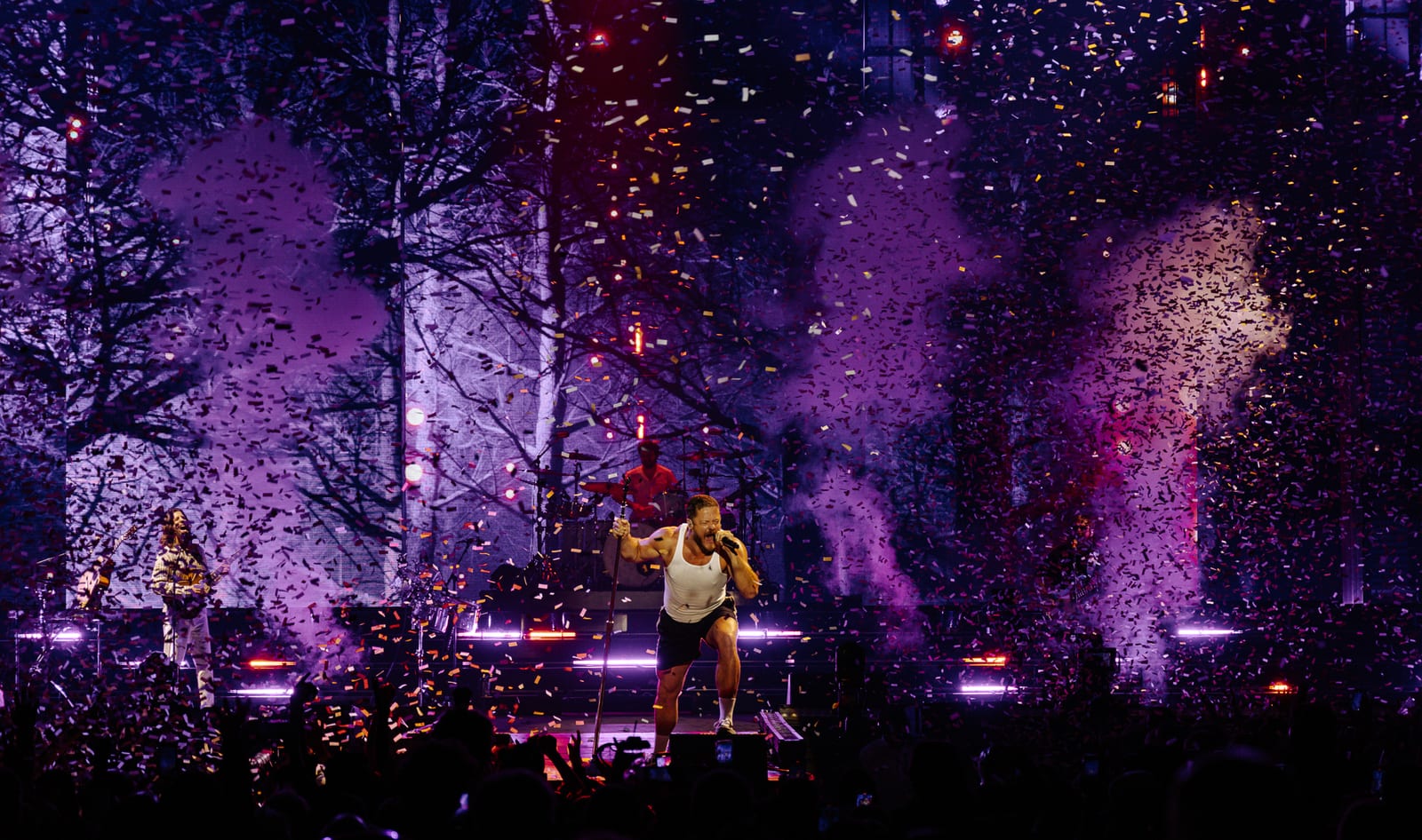 Imagine Dragons performing live amid stage lights and confetti.