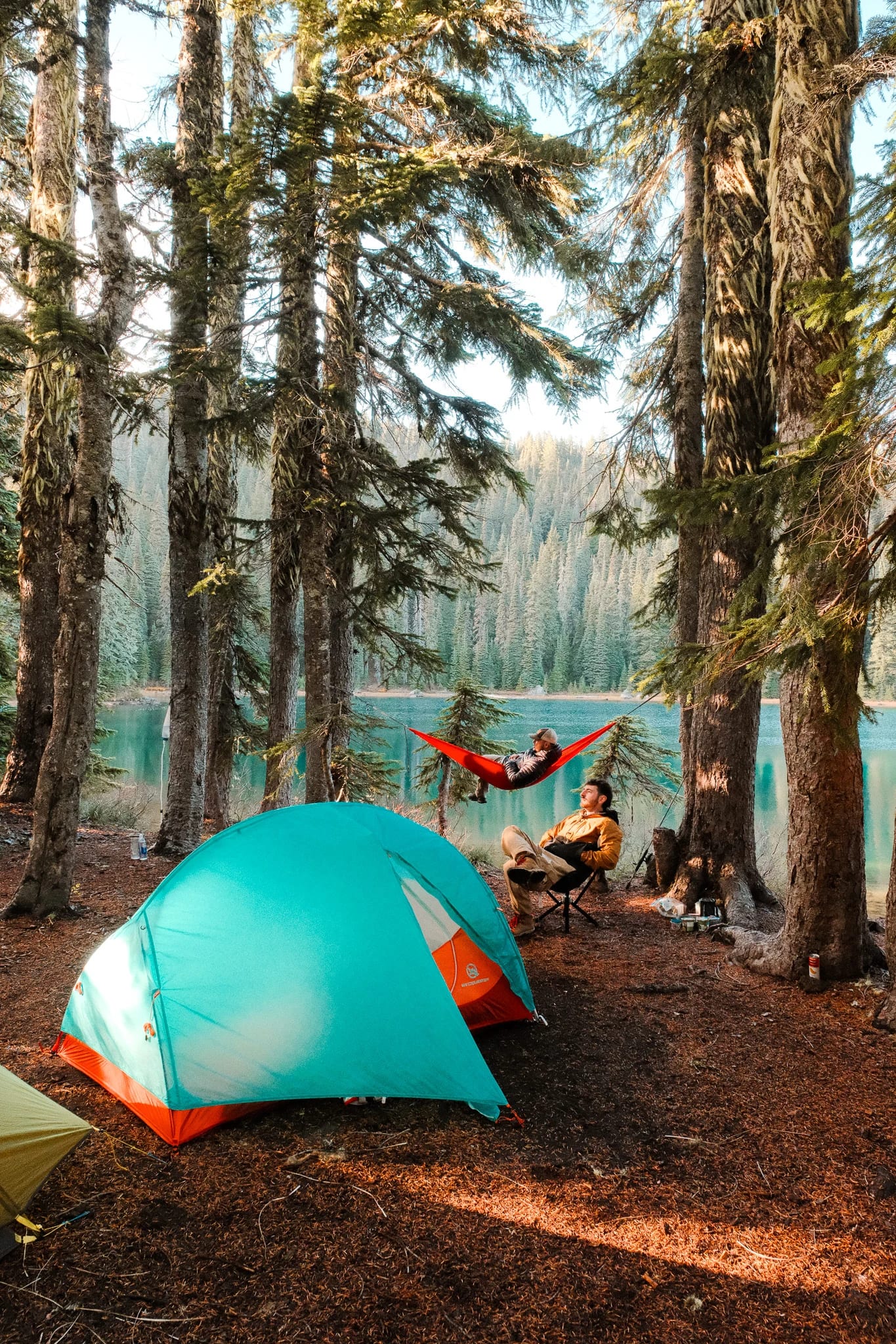 WindQuester tent, CLIQ chair and red Kammok hammock beneath tall lakeside trees