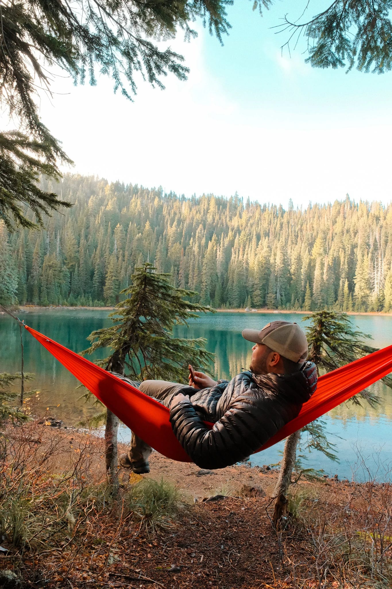 Lakeside portrait of a camper in a red Kammok hammock