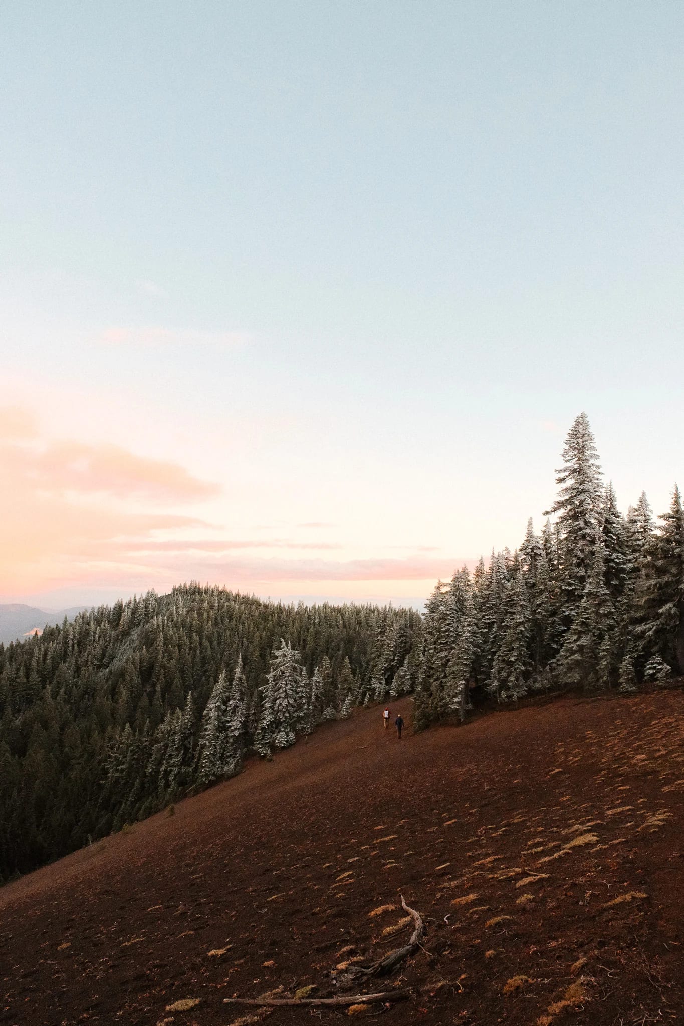Mountain ridges beyond a rocky hillside at sunset
