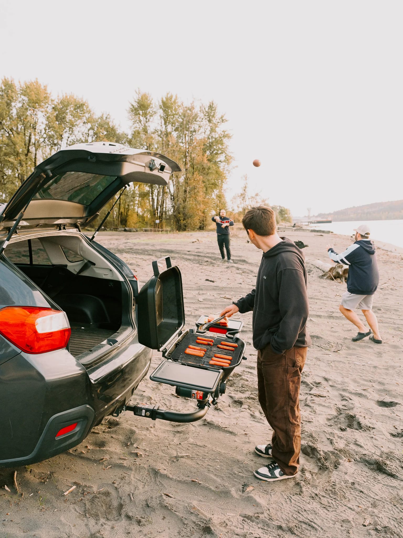 A portable cooking setup on a sandy lakeshore.