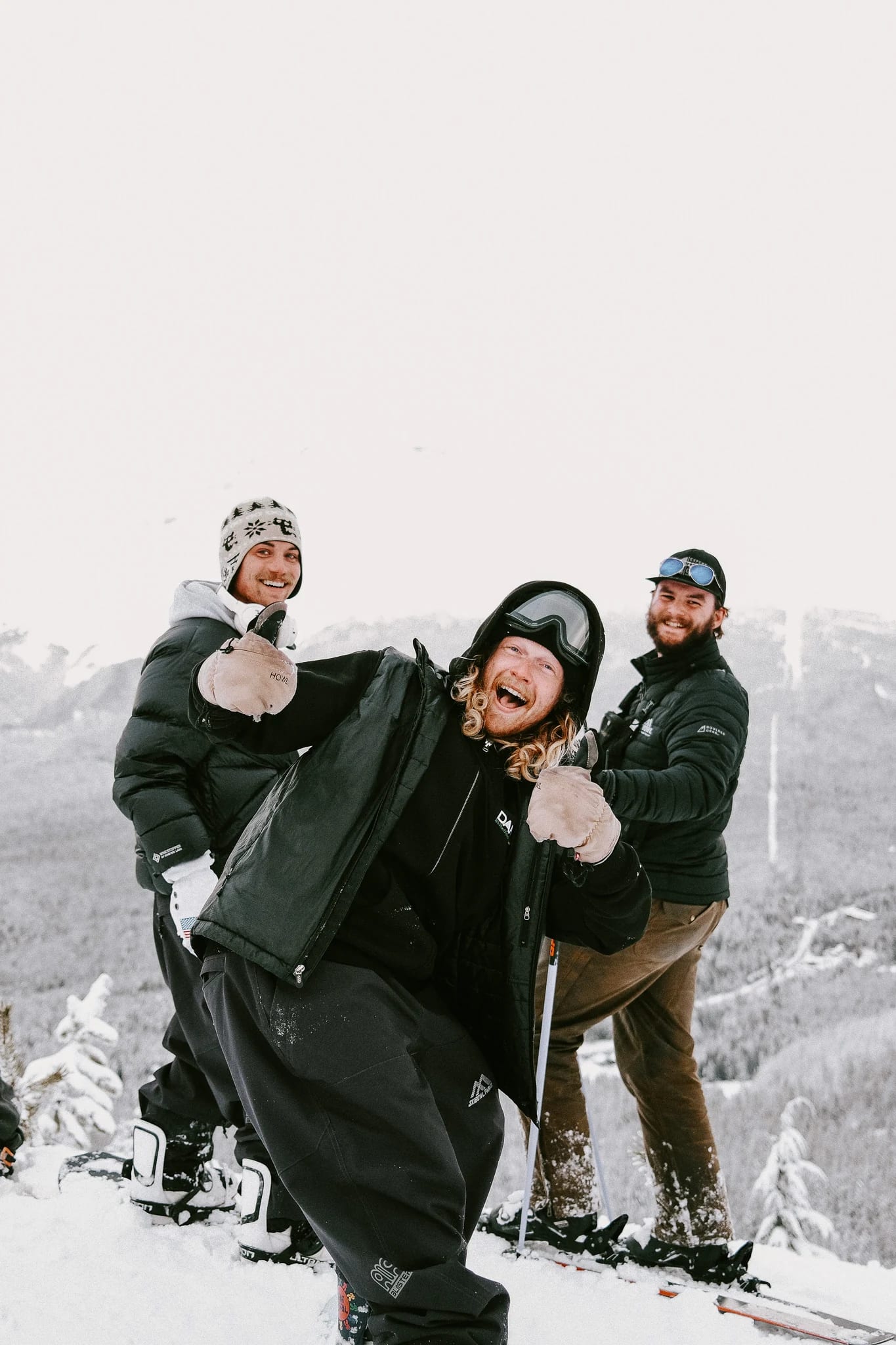 Three skiers stand together in the snow.