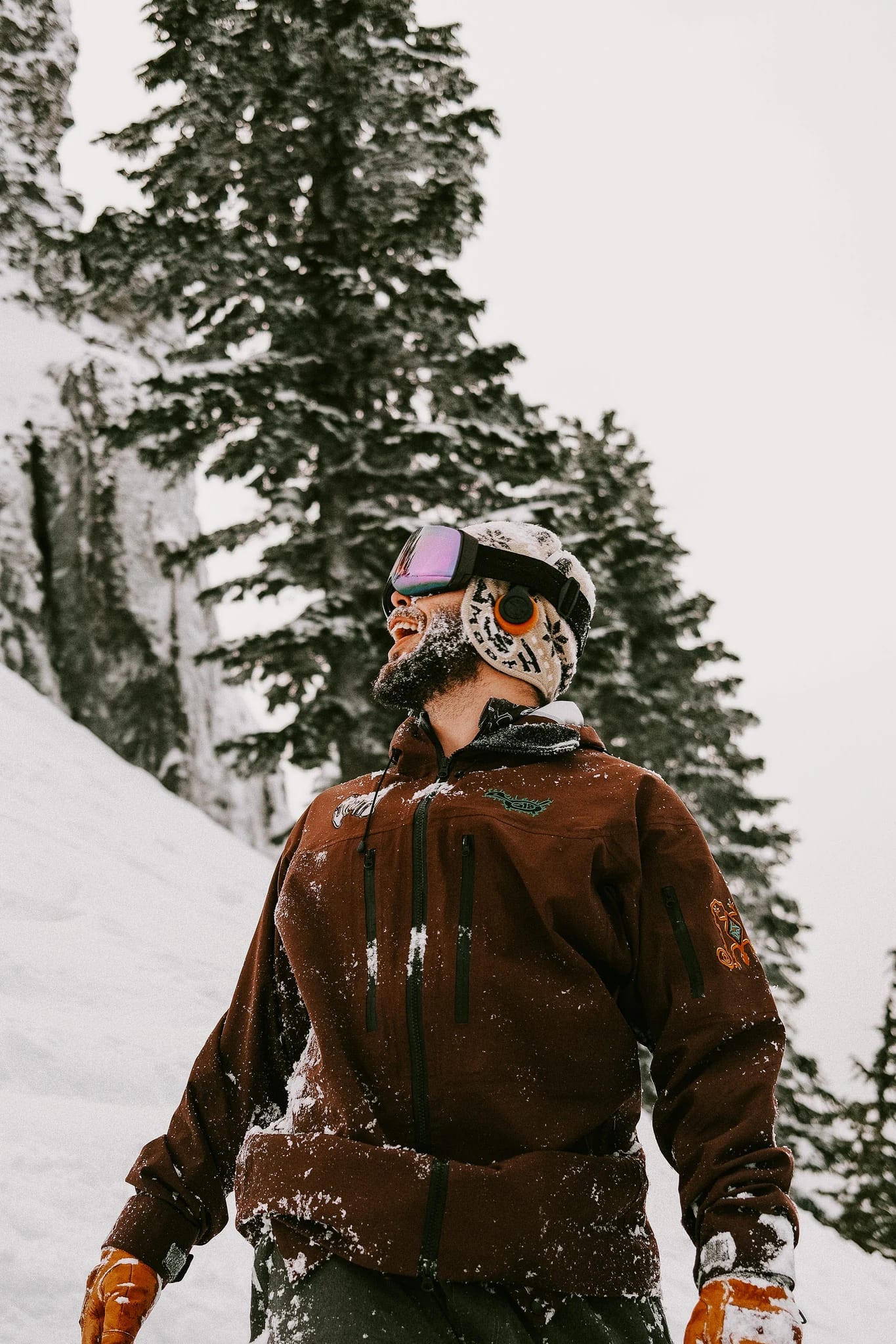 A skier carries equipment through a snowy forest.