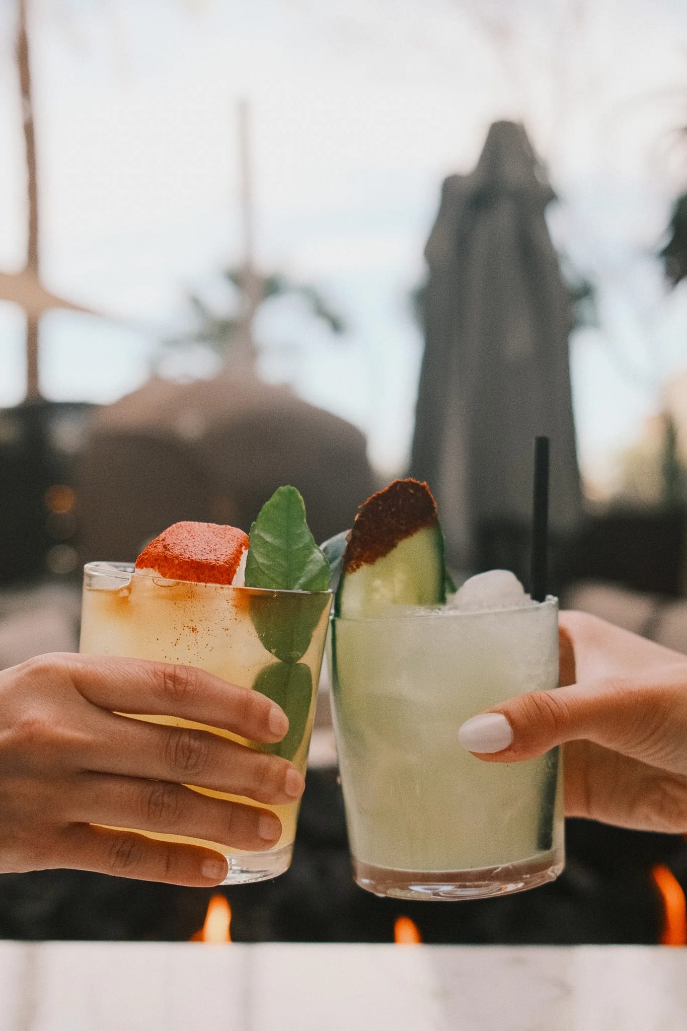 Two cocktails raised in a toast.