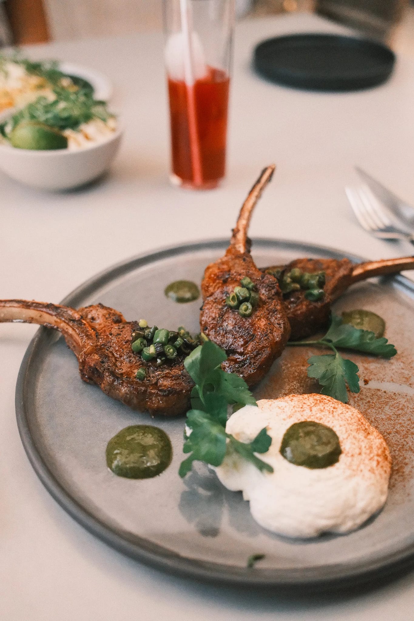 Lamb chops and a poached egg on a restaurant table.