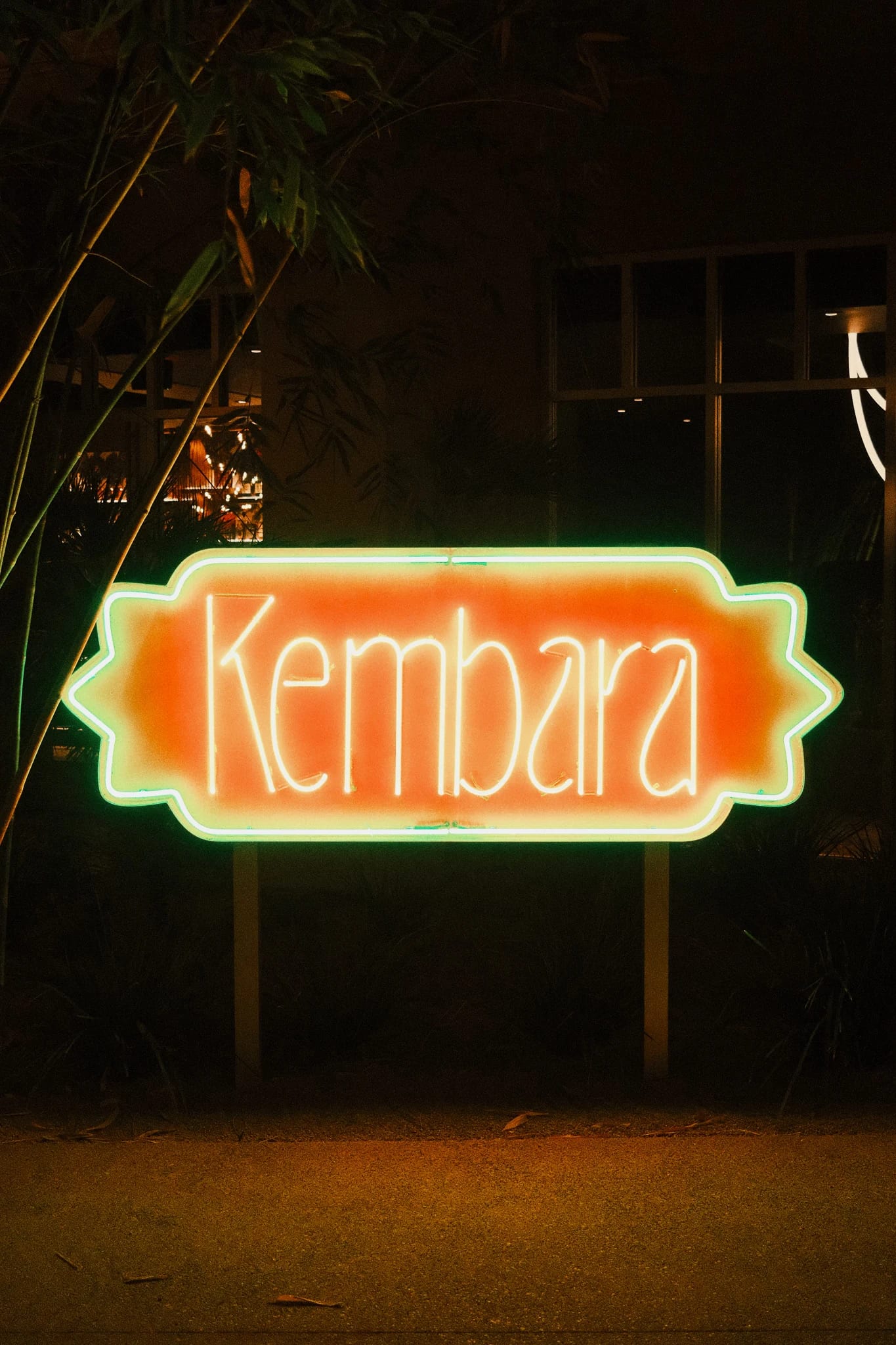 A neon Kembara sign after dark.