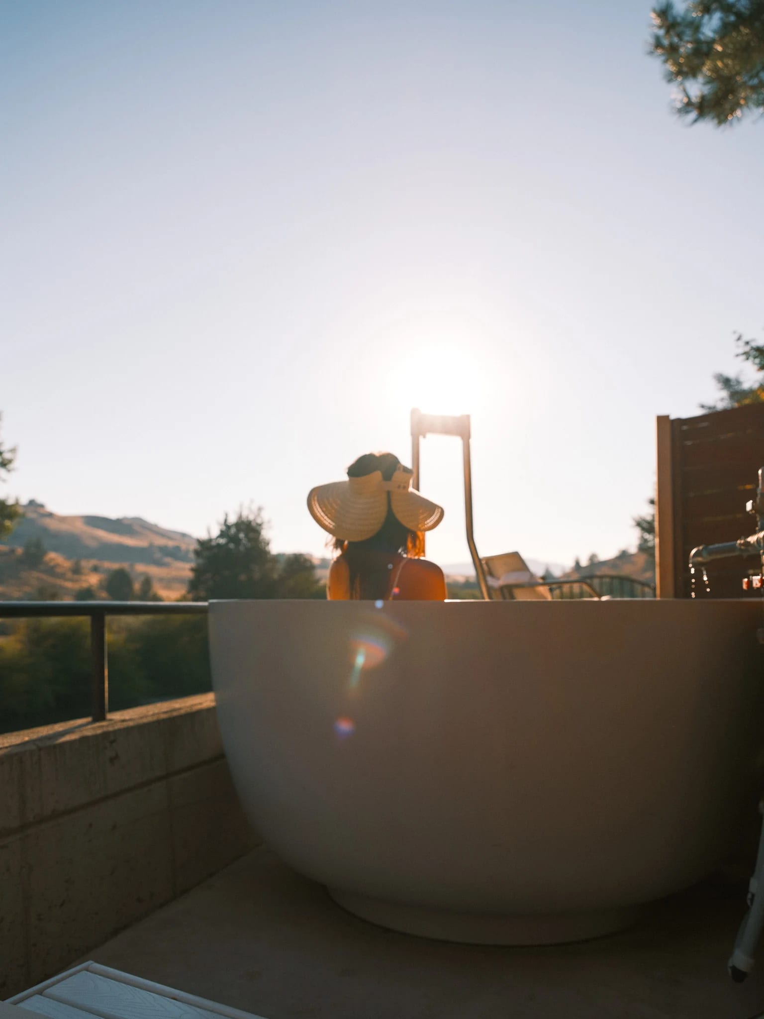 A guest relaxes in an outdoor soaking tub.
