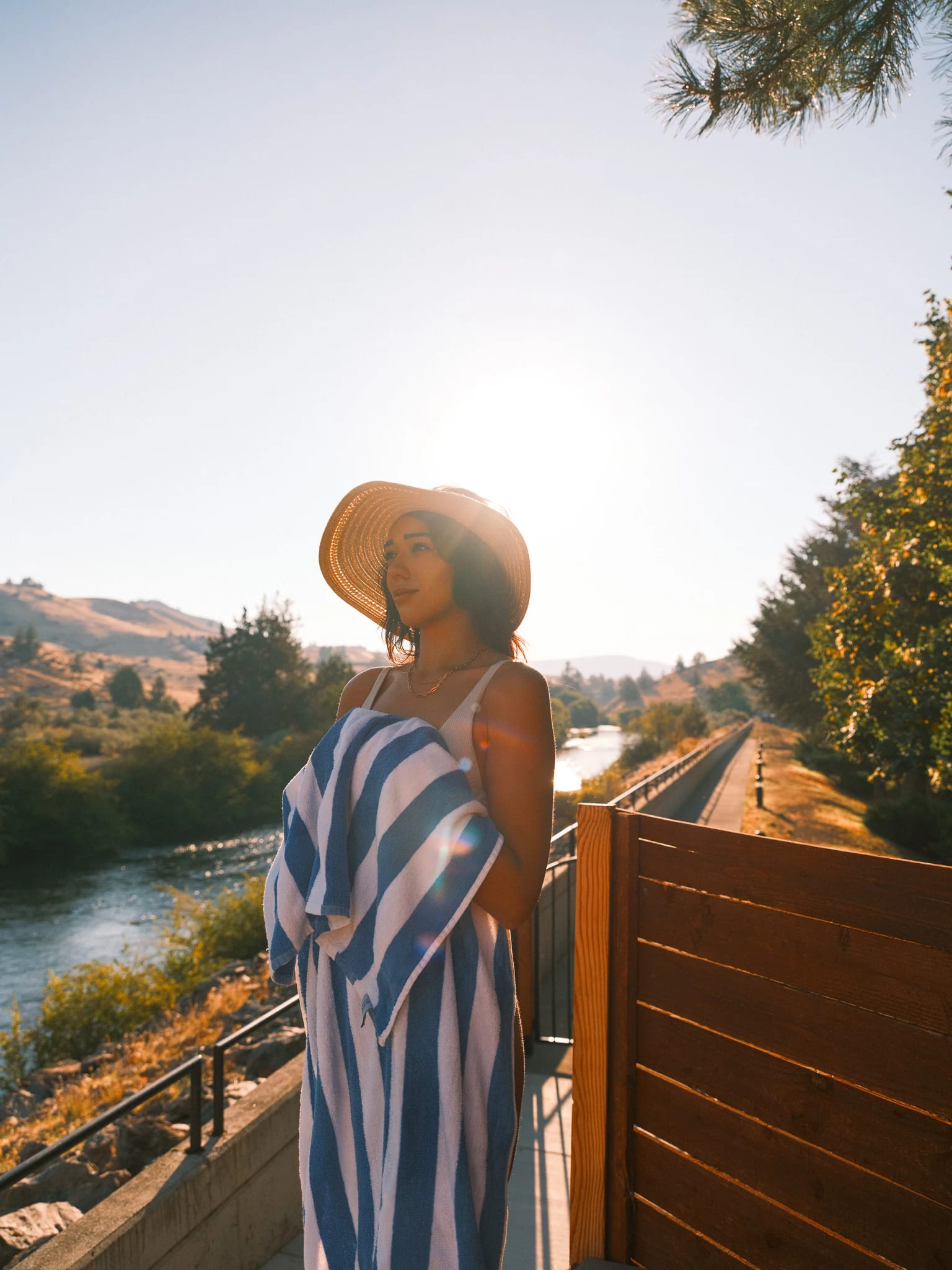 A guest in a striped towel looks out from a balcony.