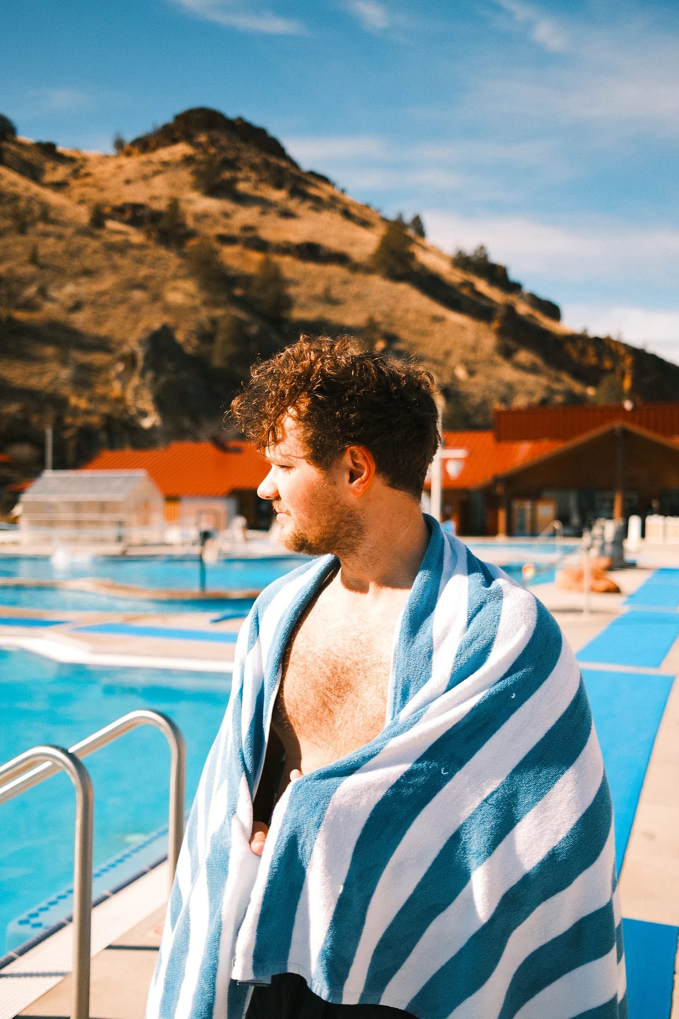A guest wrapped in a towel against golden hills.