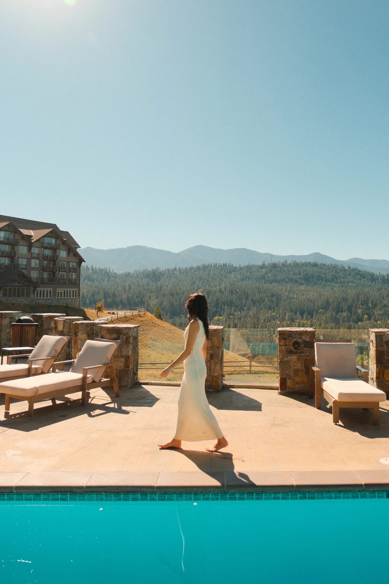 Guest walking along the poolside terrace at Suncadia