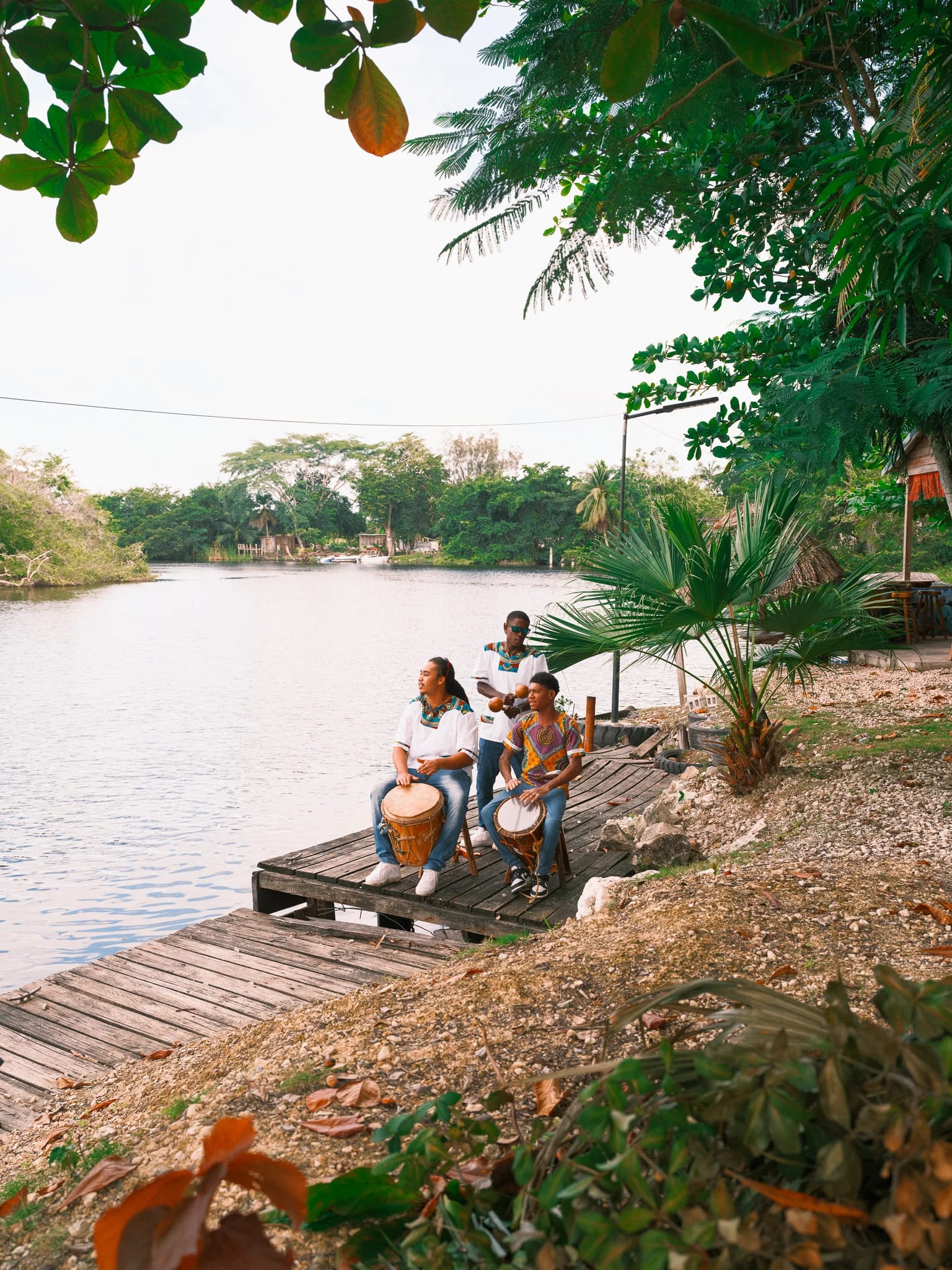 Guests relax on a dock beside a quiet river.