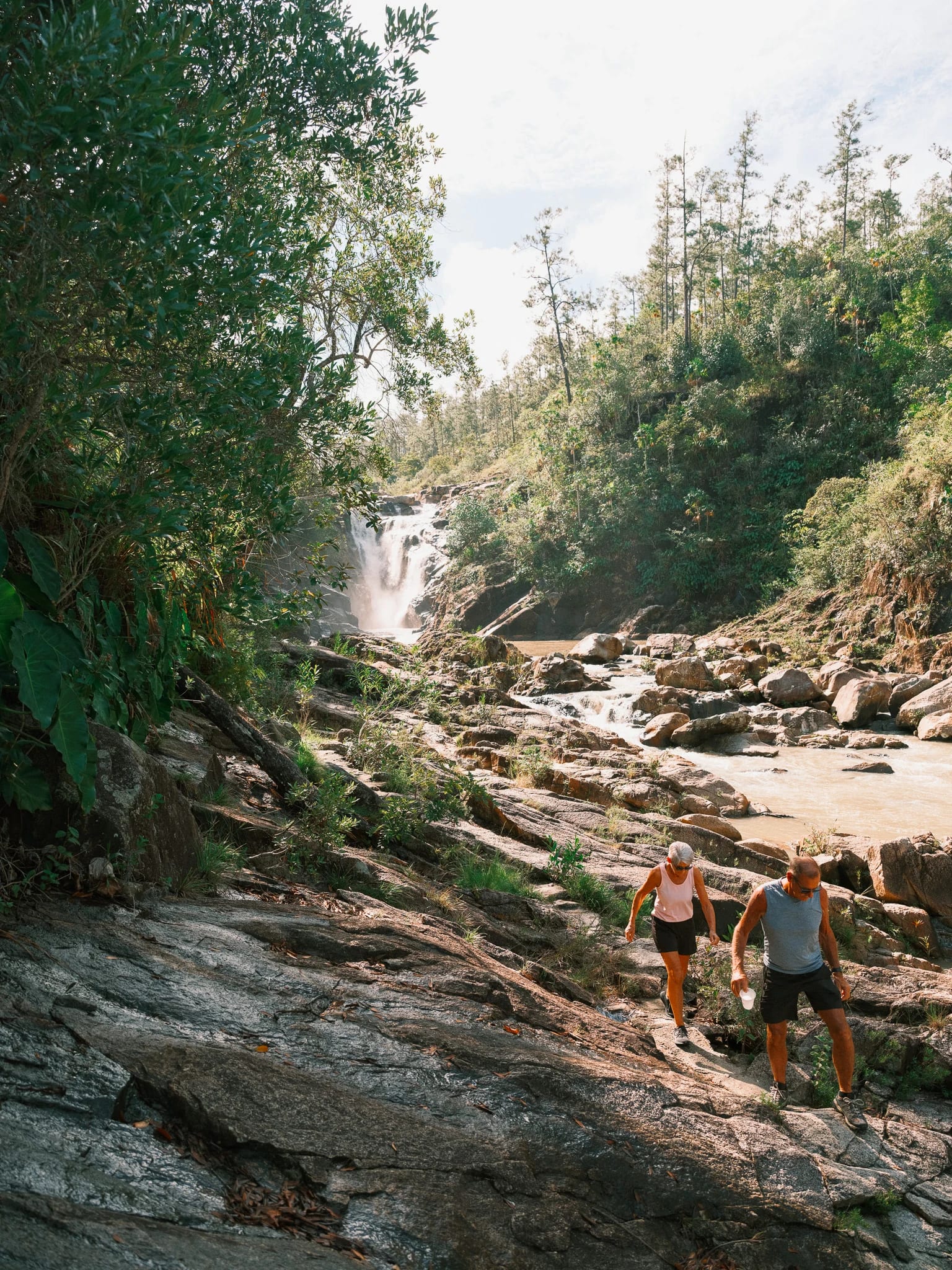 Travellers follow a rocky jungle stream.