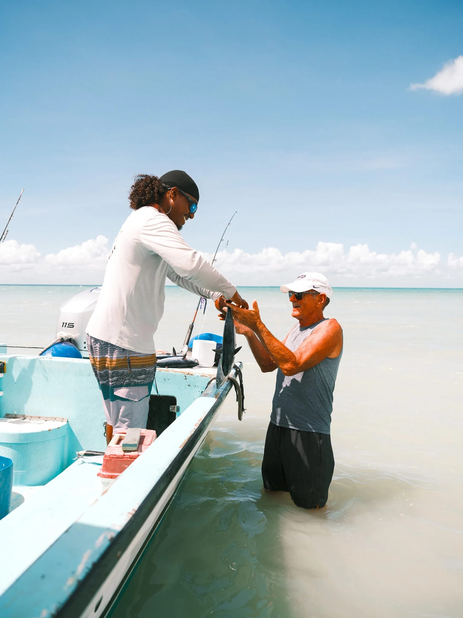 A guide helps a guest board a boat.