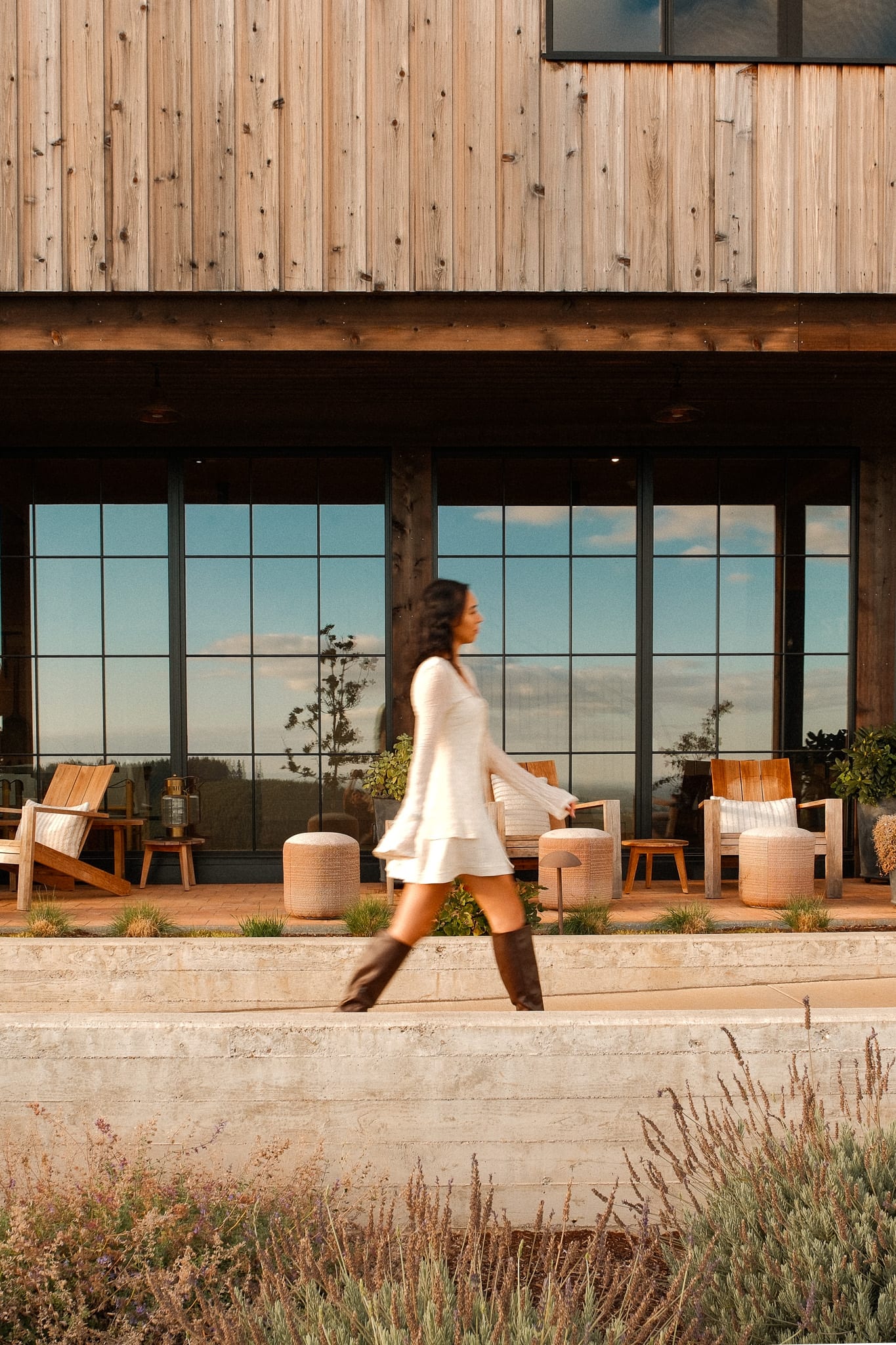 A guest crosses the courtyard in front of warm timber architecture at Black Walnut Inn.