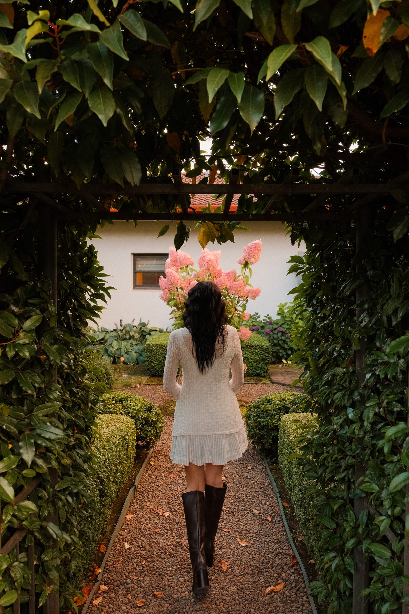 A guest walks through a leafy garden path at Black Walnut Inn.